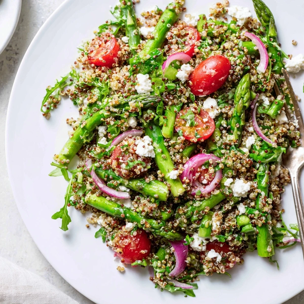 Lebendiger Spargelquinoa-Salat, serviert mit Cherry-Tomaten und frischen Kräutern.