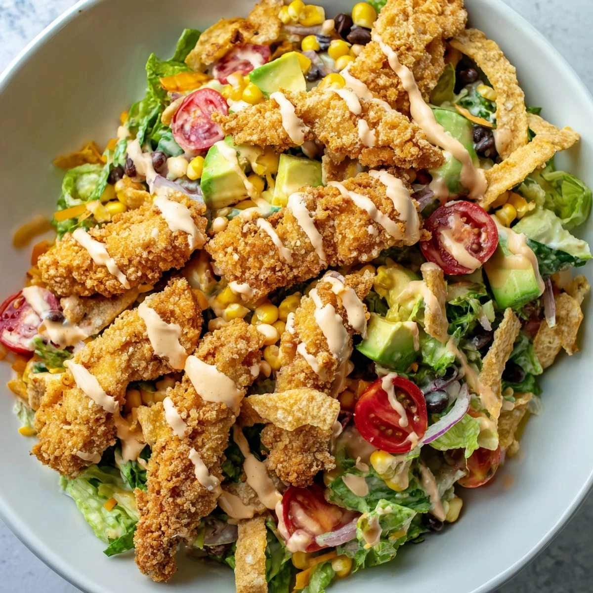 Crispy Chicken Taco Salad mit knackigen Tortillastreifen, knackigem Hähnchen und cremiger Salsa-Ranch-Dressing, liebevoll auf einem Teller angerichtet.
