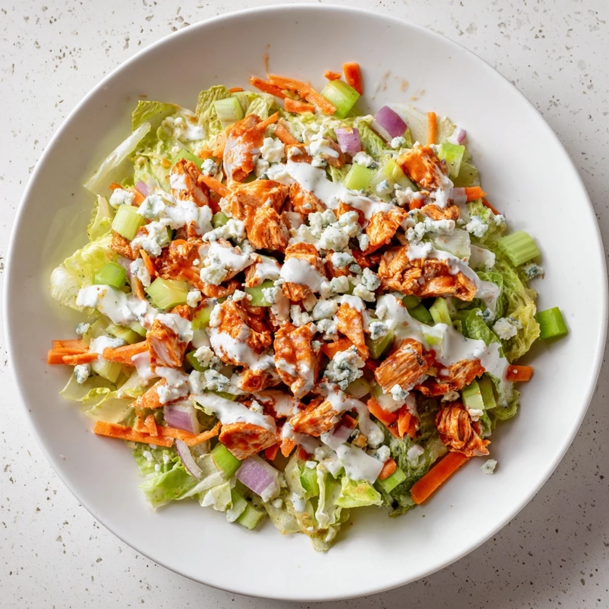 Frisch zusammengestellte Buffalo Chicken Chopped Salad mit würziger Hähnchen- und Blaukäse-Textur auf knackigem Salat.