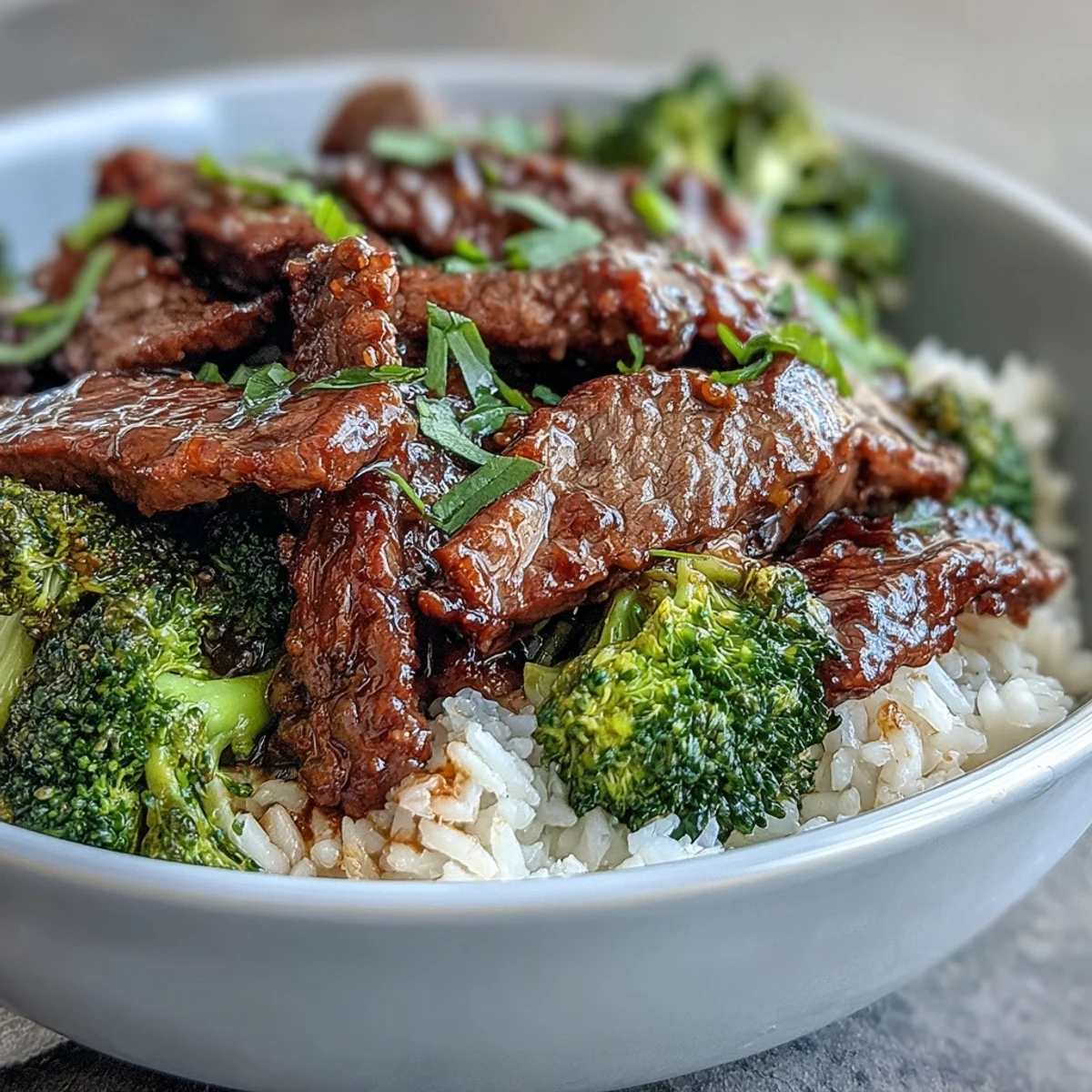 Drei leckere ALT-Texte für das Beef and Broccoli Bowl Rezept: Tender beef strips over fluffy rice with crisp steamed broccoli and a savory soy-ginger sauce.