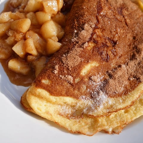 Golden fried Quarkkeulchen, served warm with homemade apple compote, perfect for breakfast.