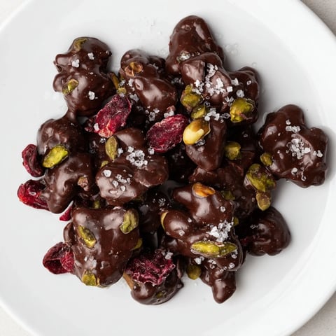 Pistachio and dried cranberry clusters: a close-up shows the delicious snack's dark chocolate coating.
