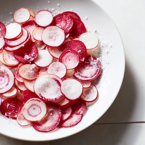 Knackige Radieschen Scheiben mit Meersalz, schmackhaft angerichtet als erfrischender Snack.