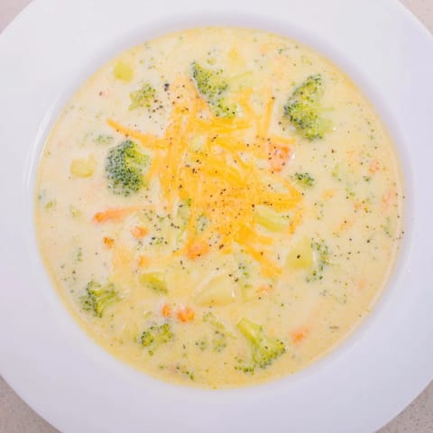 Rich and delicious creamy broccoli and cheese soup, perfect for a cozy, comforting American dinner.