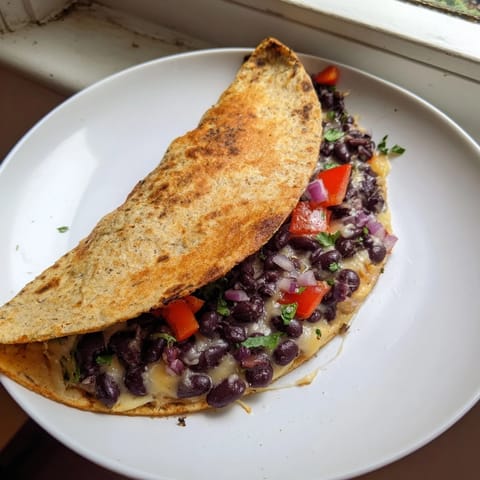 Golden-brown Vegetarian Quesadillas, filled with savory beans and cheese, ready to be cut and served.