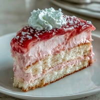 Homemade Brazo Gitano roll sliced to reveal its fluffy meringue and bright guava filling, perfect for parties.