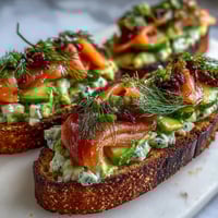 1. Lebendige Frühstücksplatte mit Avocado-Toast und geräuchertem Lachs, garniert mit frischen Tomaten, Gurke und Radieschen.  